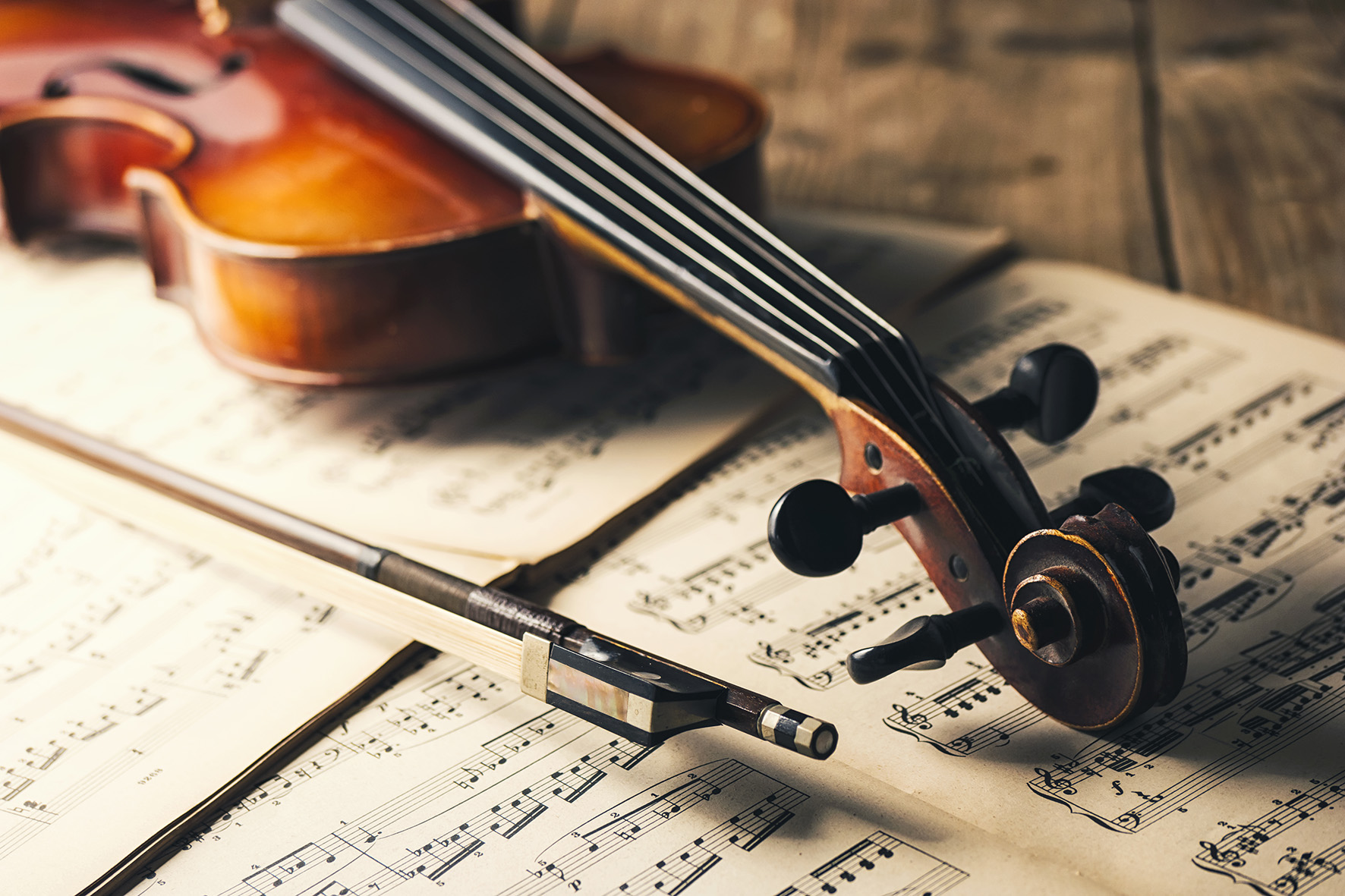 classic Violin with bow and paper notes on a wooden table. ideal for websites and magazines layouts