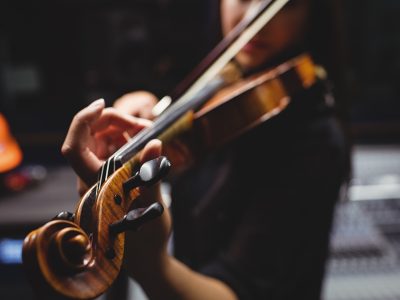 Female student playing violin in a studio