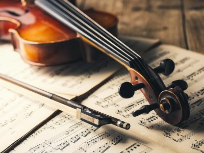 classic Violin with bow and paper notes on a wooden table. ideal for websites and magazines layouts